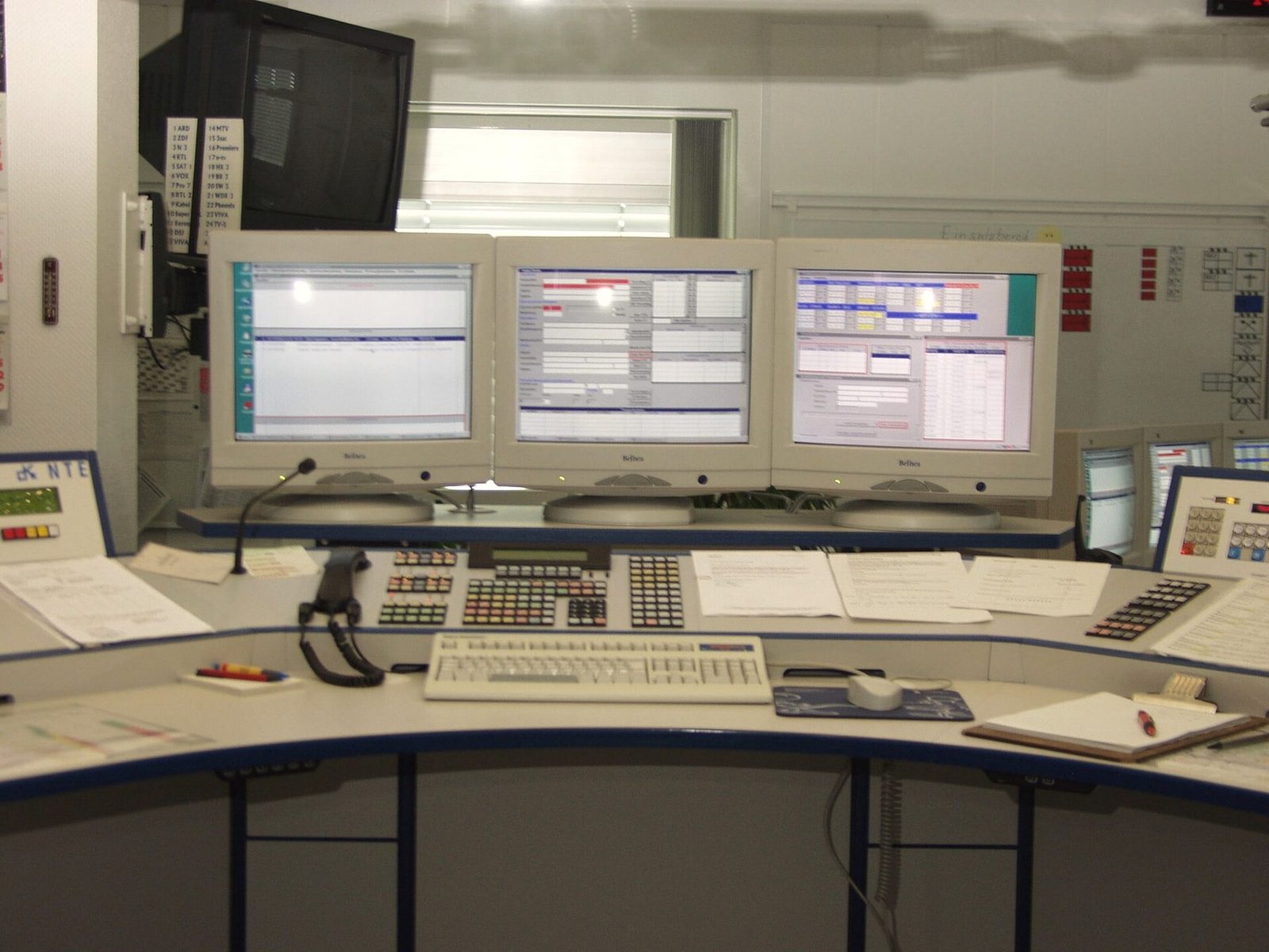 A dispatch console with multiple screens and a control keyboard.