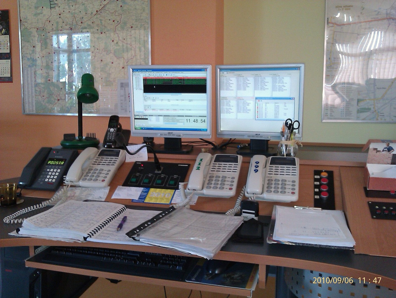 A dispatch desk with phones, screens and reference binders.
